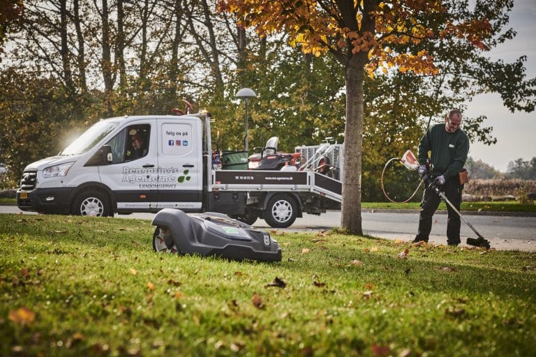 Person signing a loan agreement on a desk with a calculator nearby
